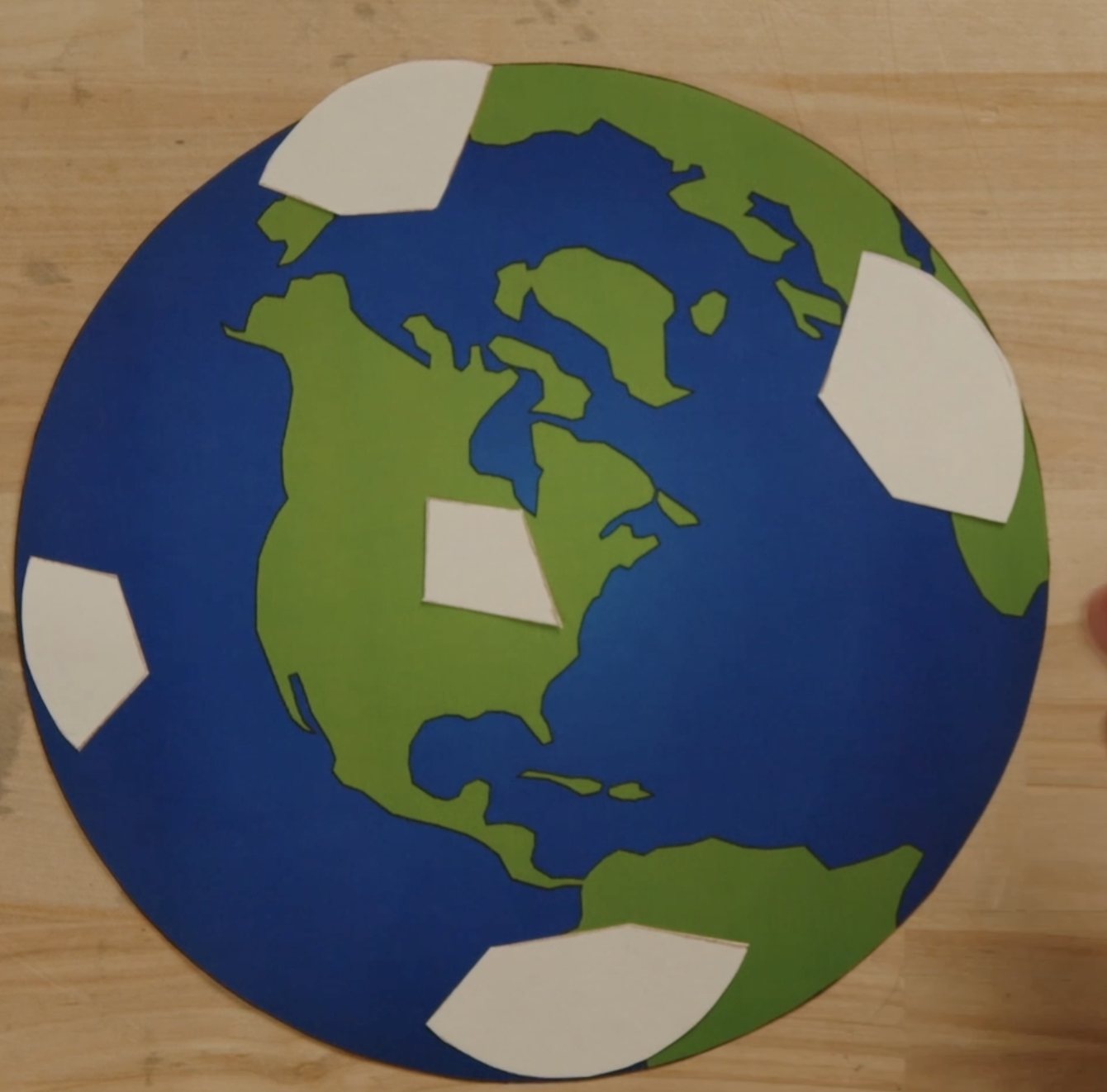 Paper Earth with blank white patches where telescopes will go